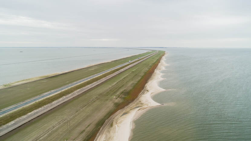 Luchtfoto van versterkte Houtribdijk met zandige oevers