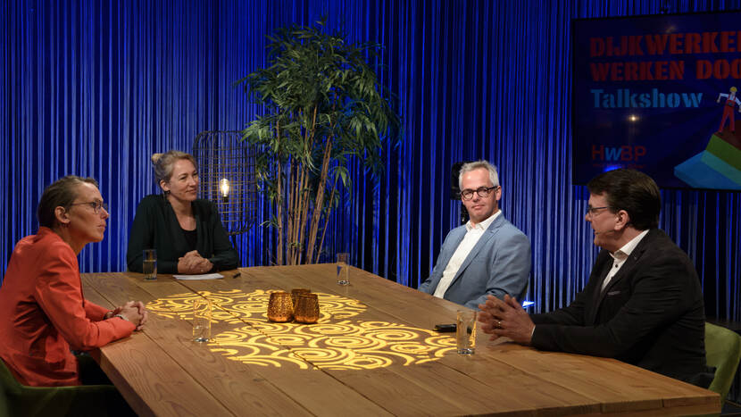 Vier gasten en presentatrice Miranda Mens aan tafel in talkshow Dijkwerkers Werken Door