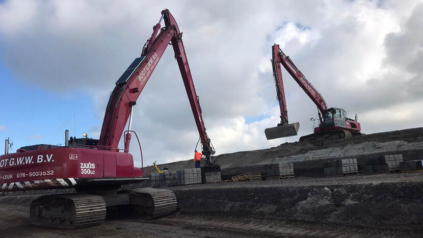 demonstratie van het plaatsen van zetstenen met graafmachines op de Lauwersdijk