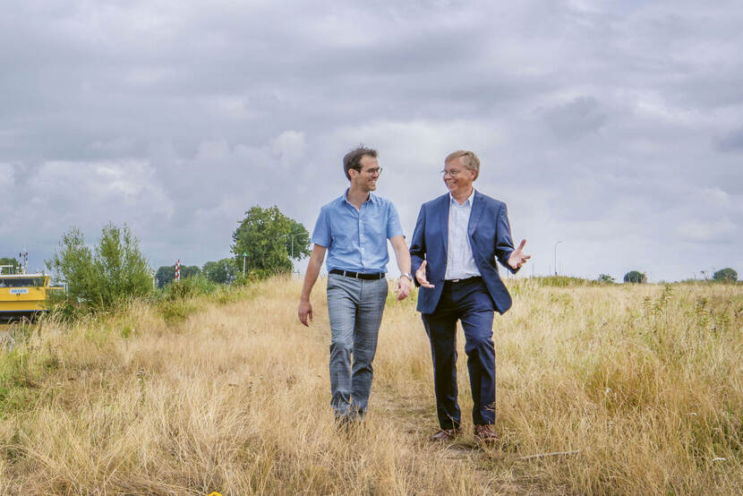 twee mannen lopen over de uiterwaarden