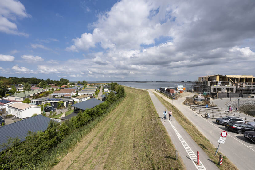 Wandelaars op de dijk langs de haven van Sint-Annaland op Tholen